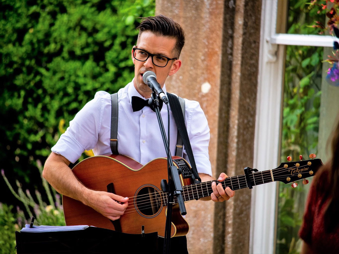 Band member performing solo acoustic songs during wedding ceremony