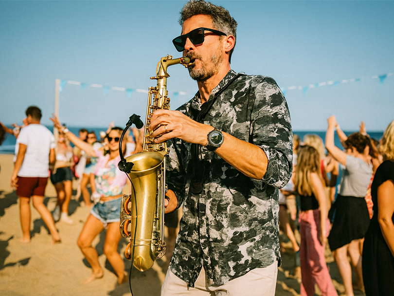 Saxophonist performing at a beach party