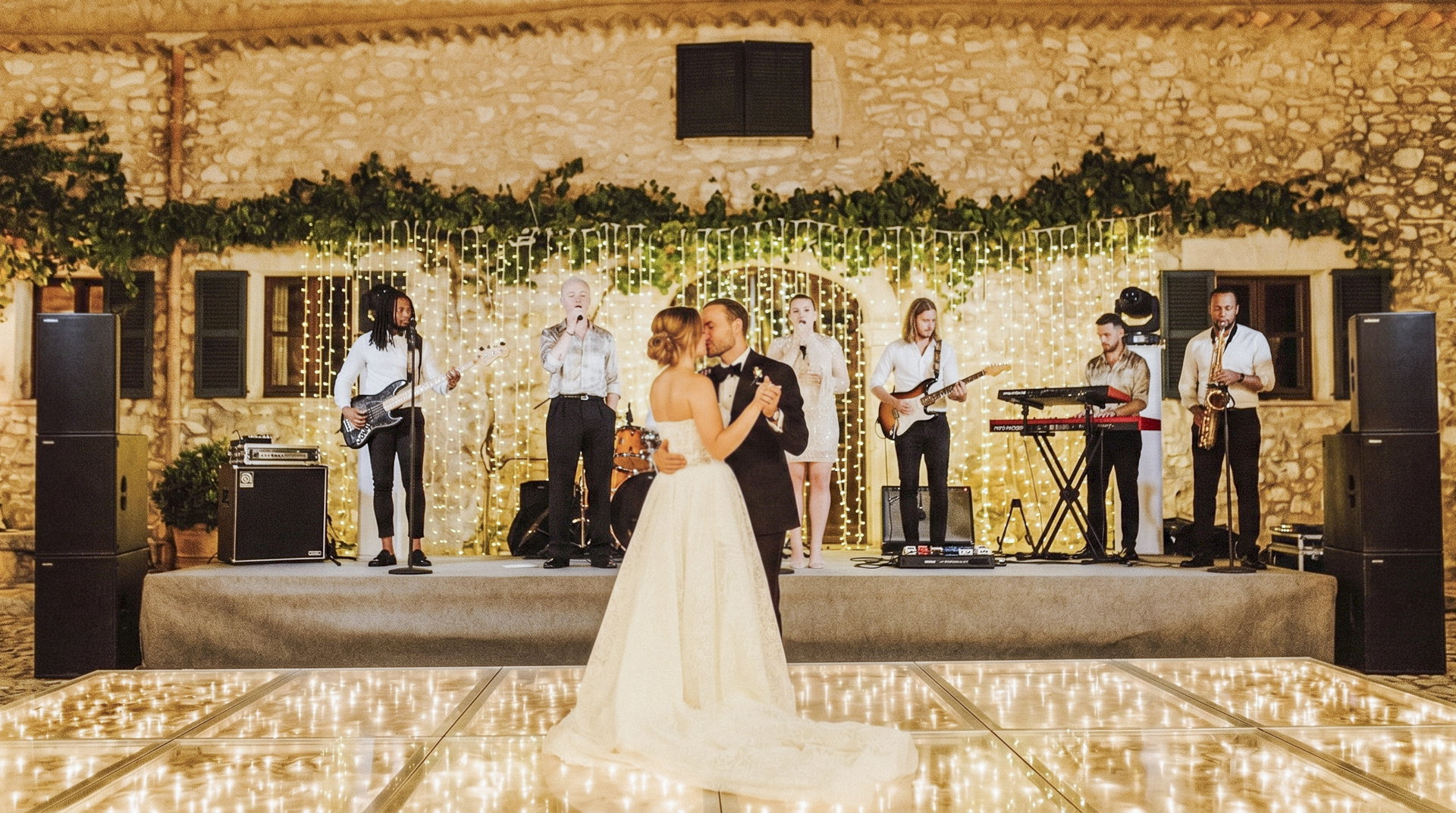 Outdoor wedding band equipment setup showing speakers, stage riser and equipment