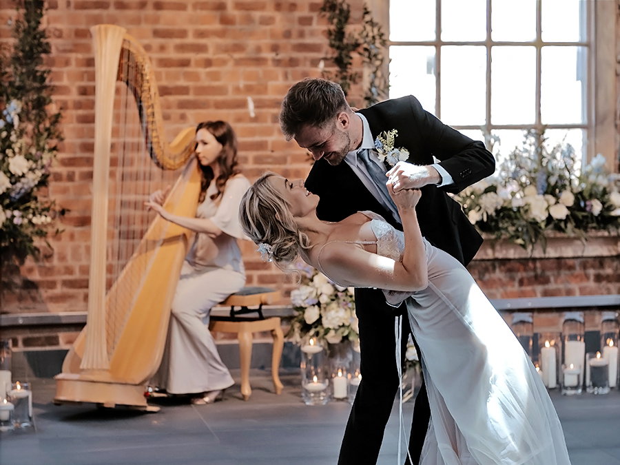 Wedding harpist performing with bride and groom dancing